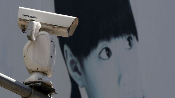 A video surveillance camera made by China's Hikvision is mounted on top of a street near a advertisement poster in Beijing. - Sputnik International