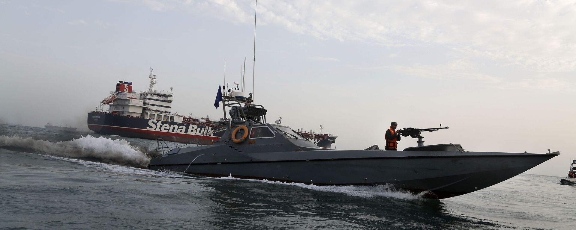 In this July 21, 2019 file photo, a speedboat of the Iran's Revolutionary Guard moves around a British-flagged oil tanker, the Stena Impero, which was seized by the Guard, in the Iranian port of Bandar Abbas.  - Sputnik International, 1920, 23.06.2025