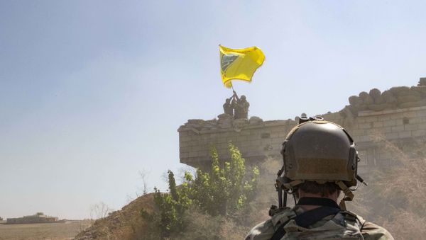 In this Sept. 21, 2019, photo, released by the U.S. Army, a U.S. soldier oversees members of the Syrian Democratic Forces as they demolish a Kurdish fighters' fortification and raise a Tal Abyad Military Council flag over the outpost as part of the so-called safe zone near the Turkish border. - Sputnik International