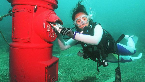 A female skin-diver puts a plastic letter into a post box set up at a depth of 10 meters on bottom of the sea off the coast of Susami, Wakayama Prefecture 07 July 1999. - Sputnik International