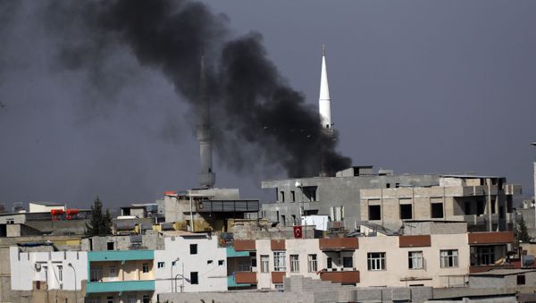  Smoke from a fire caused by an incoming mortar fired from the Syrian side, billows behind a mosque's minarets in Akcakale, Sanliurfa province, southeastern Turkey, smoke billows from targets inside Syria during bombardment by Turkish forces Thursday, Oct. 10, 2019 - Sputnik International