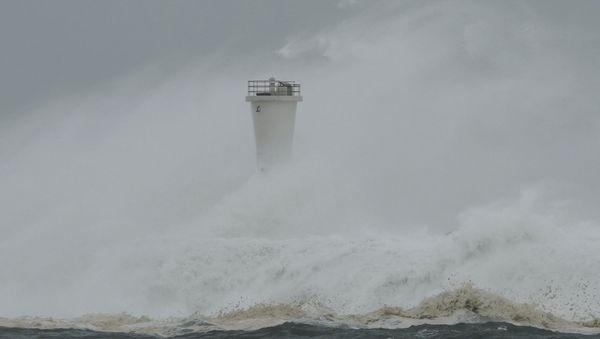 Surging waves hit against the breakwater and a lighthouse as Typhoon Hagibis approaches at a port in the town of Kiho, Mie prefecture, central Japan. - Sputnik International