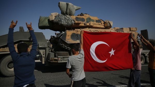 Local residents applaud as a convoy of Turkish forces trucks transporting tanks is driven in Sanliurfa province, southeastern Turkey, at the border with Syria - Sputnik International