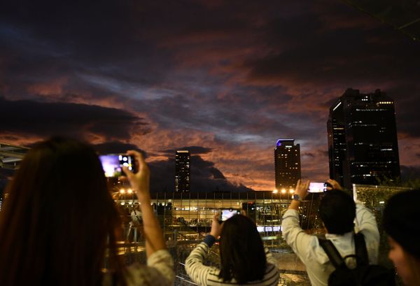 People take photos during sunset near Osaka Station, as typhoon 'Hagibis' approaches Japan, in Osaka, Japan October 12, 2019.  - Sputnik International
