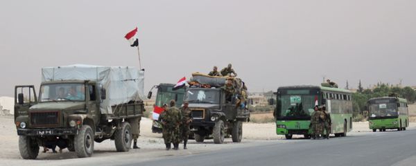 A convoy of military vehicles and  transporting Syrian regime troops are stationed on the outskirts of the northern Syrian border town of Kobane (also known as Ain Arab) on October 16, 2019 - Sputnik International