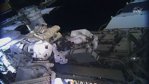 This image taken from NASA TV shows, astronaut Christina Koch (C L) and Jessica Meir (C R) during their spacewalk at the International Space Station on October 18, 2019. - Sputnik International