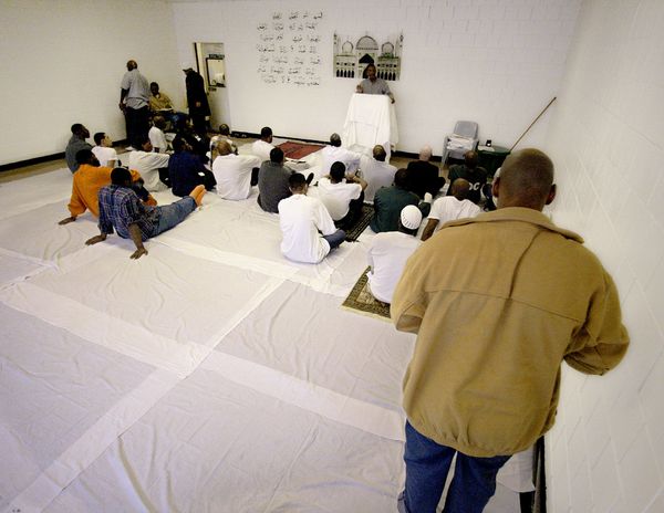 The Rikers Island jail complex has places for inmates to pray. This file photo shows Imam Menelik Muhammad standing beside the Quranic prayer on a wall facing Mecca. - Sputnik International