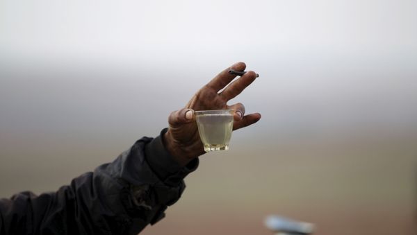 A worker shows off the final fuel product at a makeshift oil refinery site in Marchmarin town, southern countryside of Idlib, Syria December 16, 2015. - Sputnik International