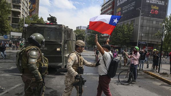   Army soldiers stop a man protesting with a Chilean flag, after a night of riots that forced President Sebastian Pinera to announce a state of emergency, in Santiago, Chile, Saturday, Oct. 19, 2019. - Sputnik International