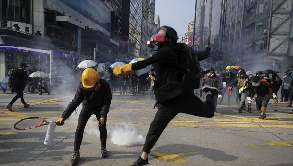 Protesters throw away the tear gas canisters fired by riot policemen during a rally in Hong Kong, Sunday, Oct. 20, 2019 - Sputnik International