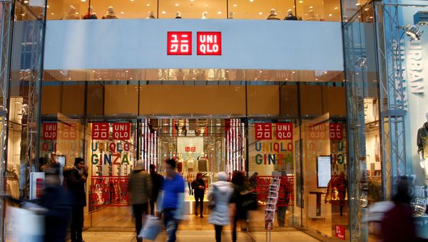 People walk past Japan's Fast Retailing Co Ltd's Uniqlo signboard at its shop in Tokyo, Japan January 12, 2017 - Sputnik International