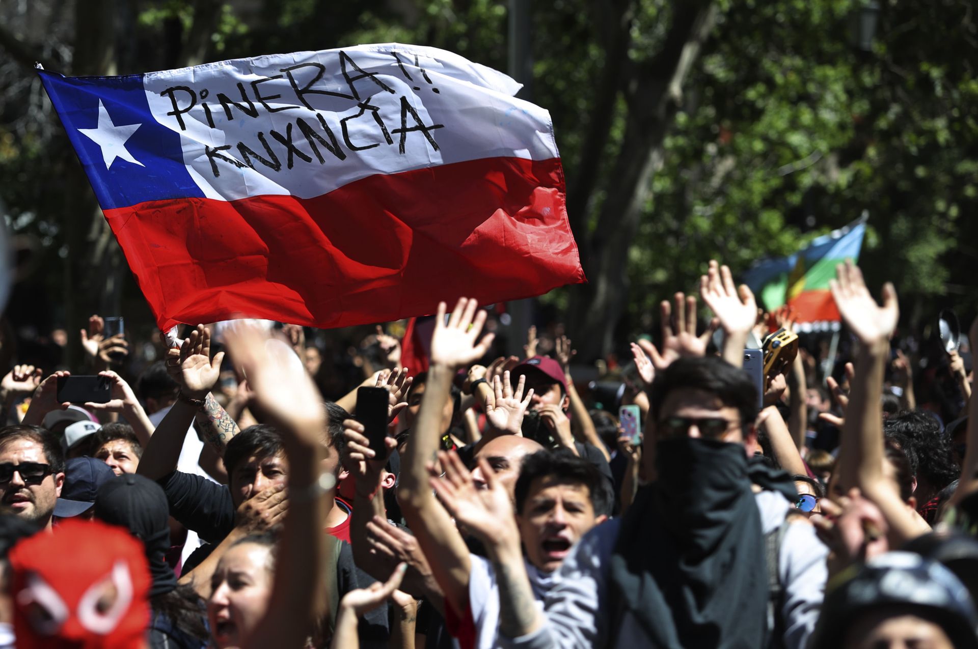 Protesters wave a Chilean flag, marked with a message that reads in Spanish: Pinera quit during a demonstration in Santiago, Chile, Monday, Oct. 21, 2019. Protesters wave a Chilean flag, marked with a message that reads in Spanish: Pinera quit during a demonstration in Santiago, Chile, Monday, Oct. 21, 2019. - Sputnik International, 1920, 29.08.2022
