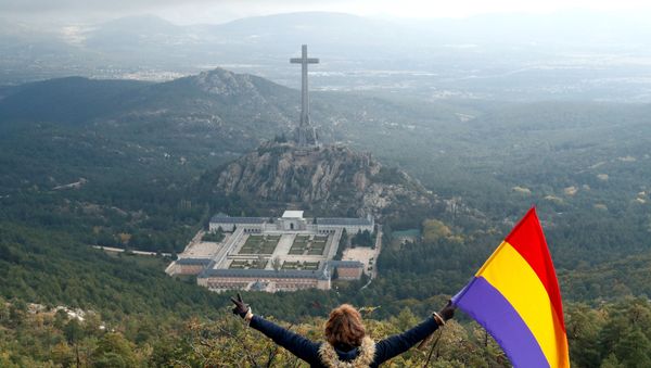 A woman holds the Spanish republican flag as she looks down on the Valley of the Fallen memorial - Sputnik International