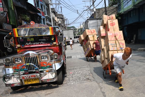 Workers pull carts loaded with goods next to a passenger jeepney along a street in Chinatown district of Manila on October 22, 2019. Workers pull carts loaded with goods next to a passenger jeepney along a street in Chinatown district of Manila on October 22, 2019. - Sputnik International