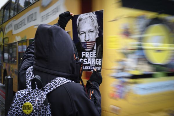 A protester holds a leaflet demanding the release of Julian Assange A protester holds a leaflet demanding the release of Julian Assange - Sputnik International