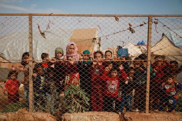 Displaced Syrian children stand behind a fence outside their tents in a camp set up near the village of Kafr Lusin, in Idlib's northern countryside near the Syria-Turkey border, on October 22, 2019. Displaced Syrian children stand behind a fence outside their tents in a camp set up near the village of Kafr Lusin, in Idlib's northern countryside near the Syria-Turkey border, on October 22, 2019. - Sputnik International