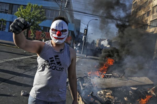 A masked demonstrator raises his clenched fist at a burning barricade during protests in Valparaiso, Chile, on October 20, 2019. A masked demonstrator raises his clenched fist at a burning barricade during protests in Valparaiso, Chile, on October 20, 2019. - Sputnik International