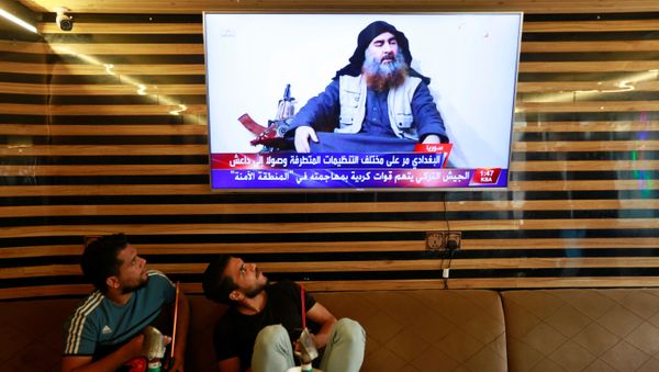 Iraqi youth watch the news of Islamic State leader Abu Bakr al-Baghdadi death, in Najaf, Iraq October 27, 2019.  - Sputnik International