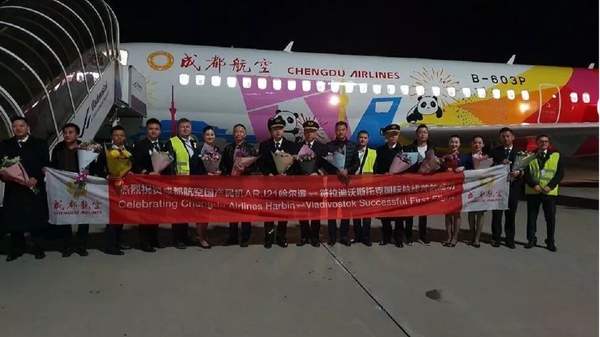 Pilots, crew and Russian ground support crew celebrating the success of the maiden international commercial flight of the new ARJ21 regional airliner. - Sputnik International
