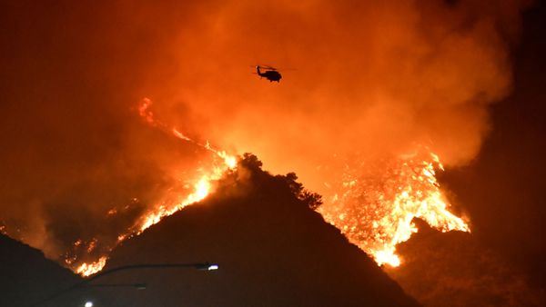 A firefighting helicopter flies over the Getty Fire as it burns in the hills west of the 405 freeway in the hills of West Los Angeles, California, U.S. October 28, 2019 - Sputnik International