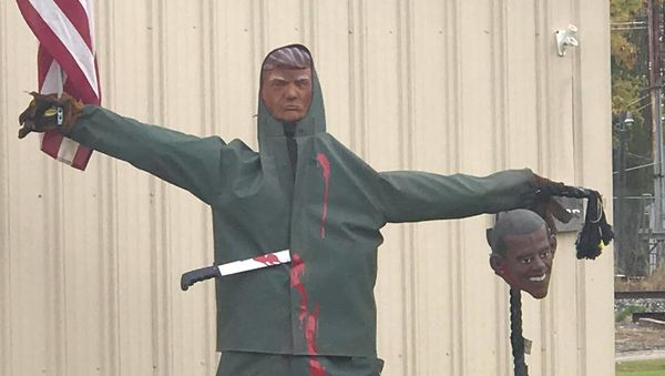Auto shop's Halloween decor shows Trump scarecrow holding up a Trump head, posted by Facebook user Kathy DeTroyer  - Sputnik International