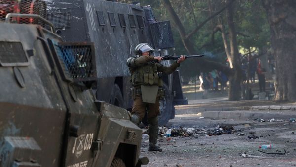 A police officer aims his weapon during a protest against Chile's government in Santiago, Chile October 30, 2019 - Sputnik International