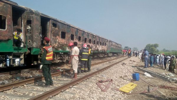 People and rescue workers gather near the site after a fire broke out in a passenger train and destroyed three carriages near the town of Rahim Yar Khan, Pakistan October 31, 2019 - Sputnik International