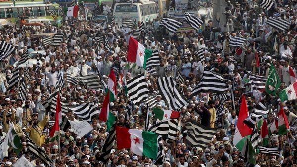 Supporters of religious and political party Jamiat Ulema-i-Islam-Fazal (JUI-F) wave flags as they listen to the speech of their leaders while heading towards Islamabad city, during what they call Azadi March (Freedom March) to protest the government of Prime Minister Imran Khan in Lahore, Pakistan October 30, 2019 - Sputnik International