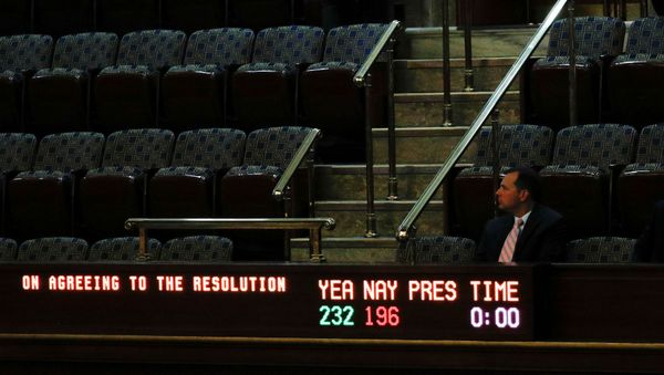 A man sits in the visitors gallery above the floor of the U.S. House of Representatives as a display board shows the final vote tallies of 232 Yea and 196 Nay on a resolution that outlines the next steps in the impeachment inquiry of U.S. President Donald Trump on Capitol Hill in Washington, U.S., October 31, 2019 - Sputnik International