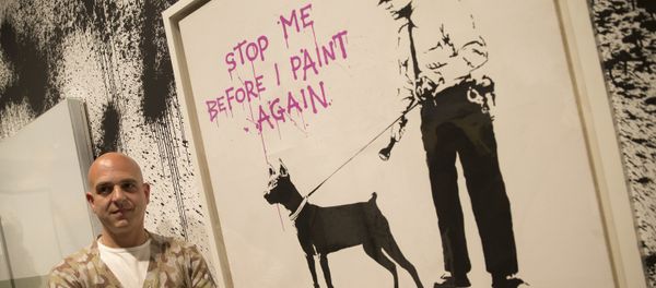 Curator Steve Lazarides poses for a portrait next to at art work by British artist Banksy, during a press preview of an unauthorized retrospective exhibition showing some 70 works of art in London, Friday, June, 6, 2014 Curator Steve Lazarides poses for a portrait next to at art work by British artist Banksy, during a press preview of an unauthorized retrospective exhibition showing some 70 works of art in London, Friday, June, 6, 2014 - Sputnik International