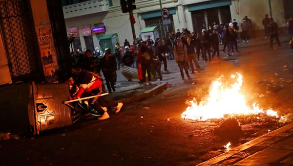Demonstrators hide behind makeshift barriers next to burning items during a protest in La Paz, Bolivia, October 31, 2019. REUTERS/Kai Pfaffenbach - Sputnik International