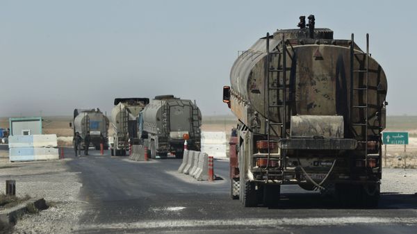 This April 4, 2018 photo shows a convoy of oil trucks passinf a Kurdish police (Assayesh) checkpoint, as they moving fuel produced in Kurdish-held areas in the east to other areas controlled by the same U.S-backed group to the west, on a highway in Hassakeh province, Syria.  - Sputnik International