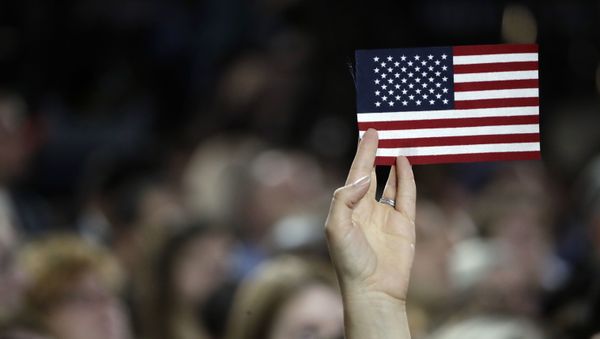 A small American flag is held aloft during Democratic presidential nominee Hillary Clinton's election night rally in the Jacob Javits Center glass enclosed lobby in New York, Tuesday, Nov. 8, 2016. - Sputnik International