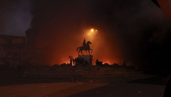 Anti-government protests set fire while security forces fired live ammunition and tear gas near the state-run TV in Baghdad - Sputnik International