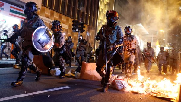 Police passes a burning barricade to break up thousands of anti-government protesters during a march billed as a global emergency call for autonomy, in Hong Kong, China November 2, 2019 - Sputnik International