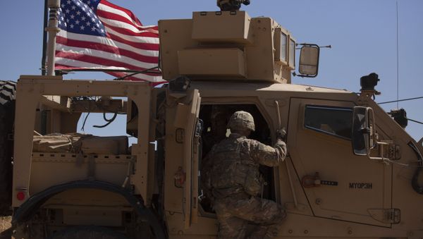 In this Sept. 8, 2019, photo, a U.S. soldier climbs into an armored vehicle during the first American-Turkish joint patrol in the so-called safe zone on the Syrian side of the border with Turkey near Tal Abyad, Syria - Sputnik International