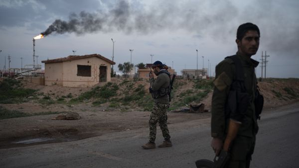 A U.S.-backed Syrian Democratic Forces (SDF) fighter talks on the radio at a check point near Omar oil field base, eastern Syria - Sputnik International