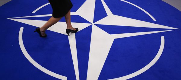 A woman walks across a carpet with the NATO logo ahead of the NATO (North Atlantic Treaty Organization) summit, at the NATO headquarters in Brussels, on July 11, 2018 A woman walks across a carpet with the NATO logo ahead of the NATO (North Atlantic Treaty Organization) summit, at the NATO headquarters in Brussels, on July 11, 2018 - Sputnik International