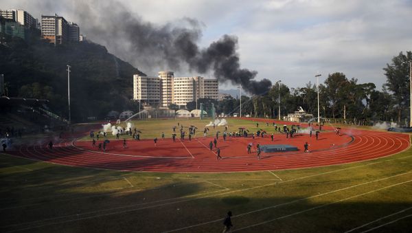 Students try to clear the tear gas canisters on a field during a face-off with police at Chinese University in Hong Kong, Tuesday, Nov. 12, 2019 - Sputnik International