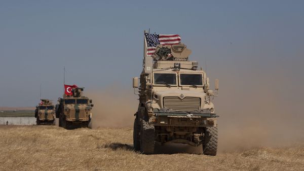 In this Sept. 8, 2019, photo, Turkish and American armored vehicles conduct the first joint patrol in the so-called safe zone on the Syrian side of the border with Turkey near Tal Abyad, Syria - Sputnik International