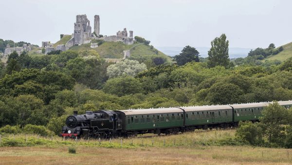 Steam locomotive Standard Class 4, makes it's way past Corfe Castle, in the background, as it travels along the Swanage railway, England, Friday July 5, 2019. - Sputnik International