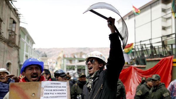 Opponents of former Bolivian President Evo Morales hold shields at a barricade set up by protesters outside presidential palace in La Paz, Bolivia, Monday, Nov. 11, 2019. - Sputnik International
