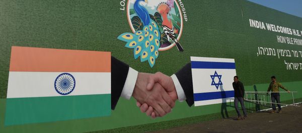 Indian workers hang a billboard bearing the national flags of Israel and India in Ahmedabad on January 16, 2018 - Sputnik International