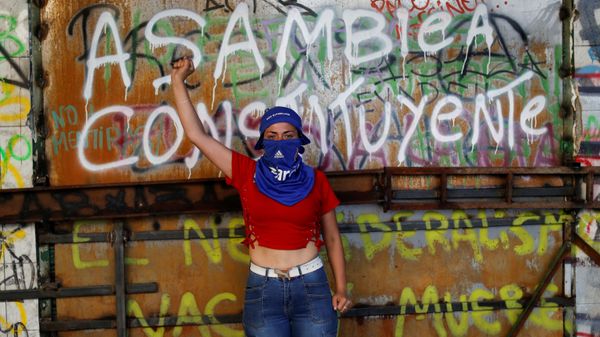 A demonstrator poses for a portrait in front of a graffiti reading Constituent Assembly during a protest against Chile's government in Santiago, Chile November 13, 2019. - Sputnik International