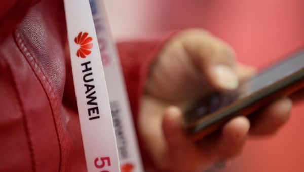  An attendee wears a badge strip with the logo of Huawei and a sign for 5G at the World 5G Exhibition in Beijing, China November 22, 2019 - Sputnik International