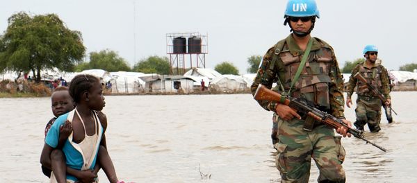 A girl holding a child walks past UN peacekeepers, after heavy rains and floods forced hundreds of thousands of people to leave their homes, in the town of Pibor, Boma state, South Sudan, November 6, 2019. A girl holding a child walks past UN peacekeepers, after heavy rains and floods forced hundreds of thousands of people to leave their homes, in the town of Pibor, Boma state, South Sudan, November 6, 2019. - Sputnik International
