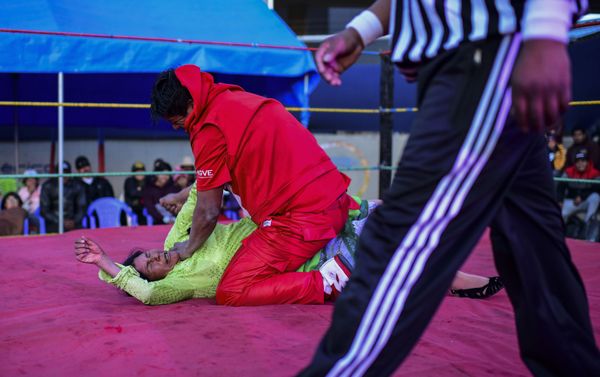 Bolivian wrestler Lidia Flores (on the canvas), aka Dina, The Queen of the Ring, member of the Fighting Cholitas, fights with a male wrestler at Sharks of the Ring wrestling club in El Alto, Bolivia, on November 24, 2019.  - Sputnik International