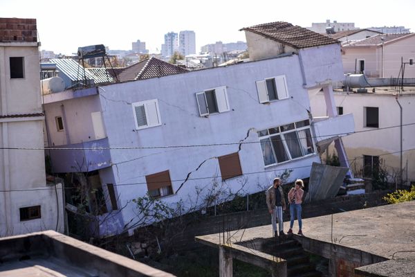 People stand in front of a collapsed building in the town of Durres, western Albania on 27 November, 2019, after an earthquake hit Albania People stand in front of a collapsed building in the town of Durres, western Albania on 27 November, 2019, after an earthquake hit Albania - Sputnik International