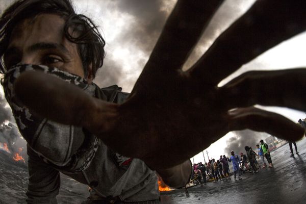 An Iraqi demonstrator runs as others burn tyres to cut off roads in the southern city of Basra on 25 November 2019. An Iraqi demonstrator runs as others burn tyres to cut off roads in the southern city of Basra on 25 November 2019. - Sputnik International
