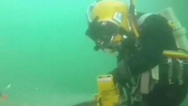 Man using a hydraulic chainsaw underwater - Sputnik International